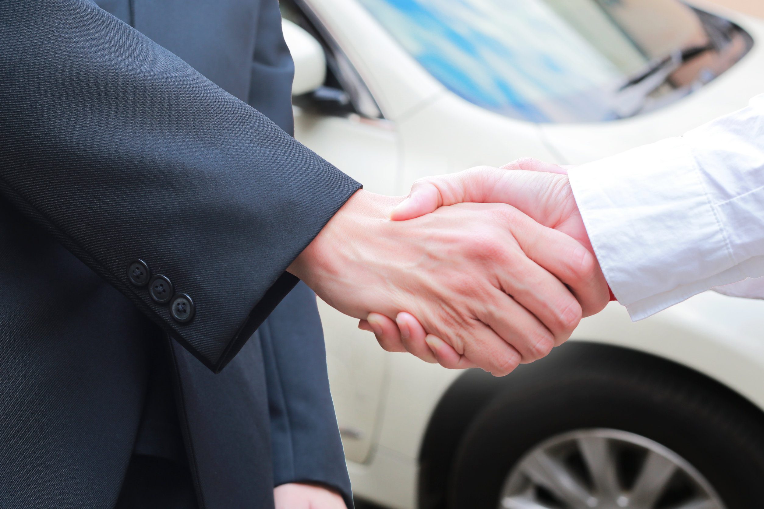 close up of male handshake in auto show or salon.